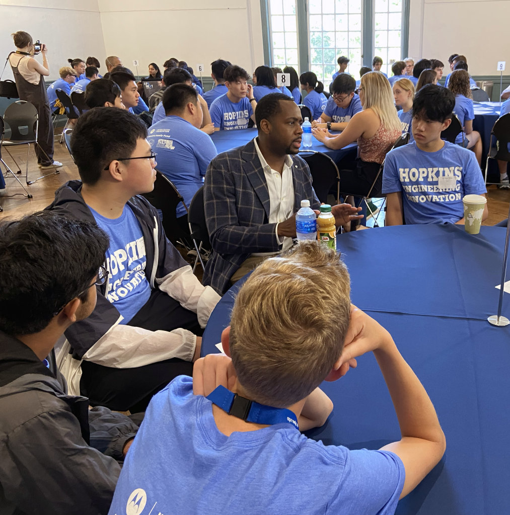 students sitting around a table and networking with a professional